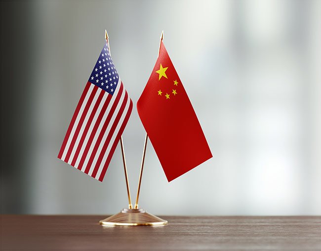 Small U.S. and China flags together on a desk