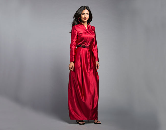 Model standing in a shiny red gown by designer Blue Meets Blue 