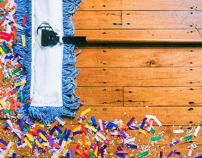 Broom cleaning up party confetti