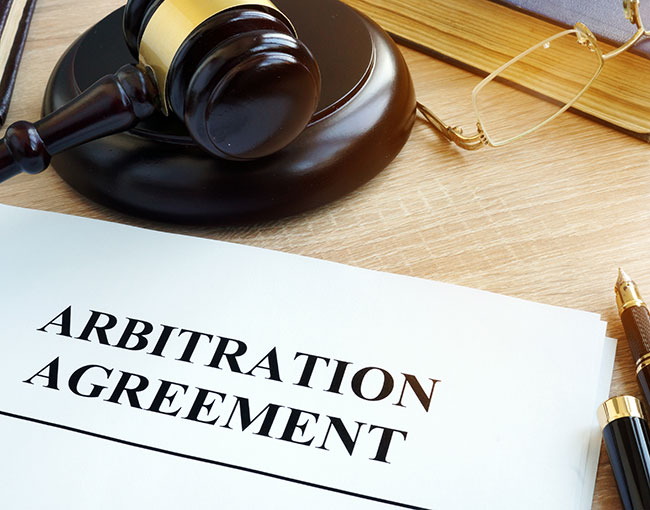 arbitration agreement with gavel and pen poised to sign it